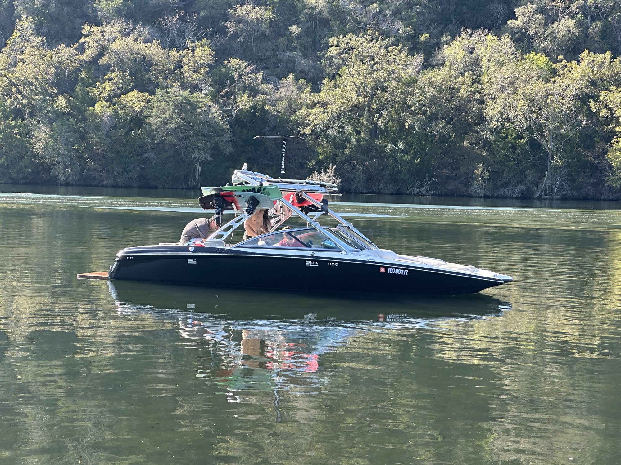 Wake boat on a calm lake with foil gear on the tower
